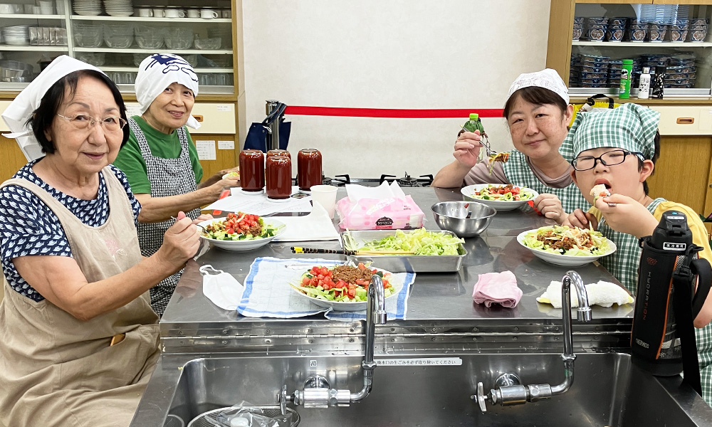 豊山シルバー人材センターのトマトケチャップ作り体験で、完成したタコライスを食べる親子