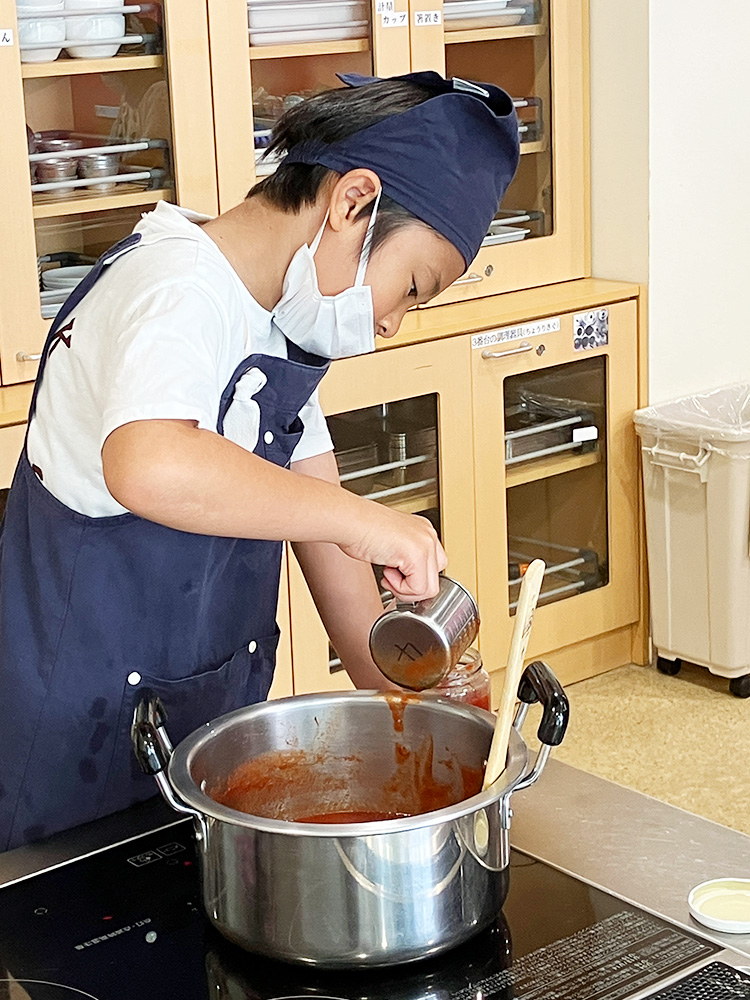 作ったトマトケチャップを瓶詰めする様子